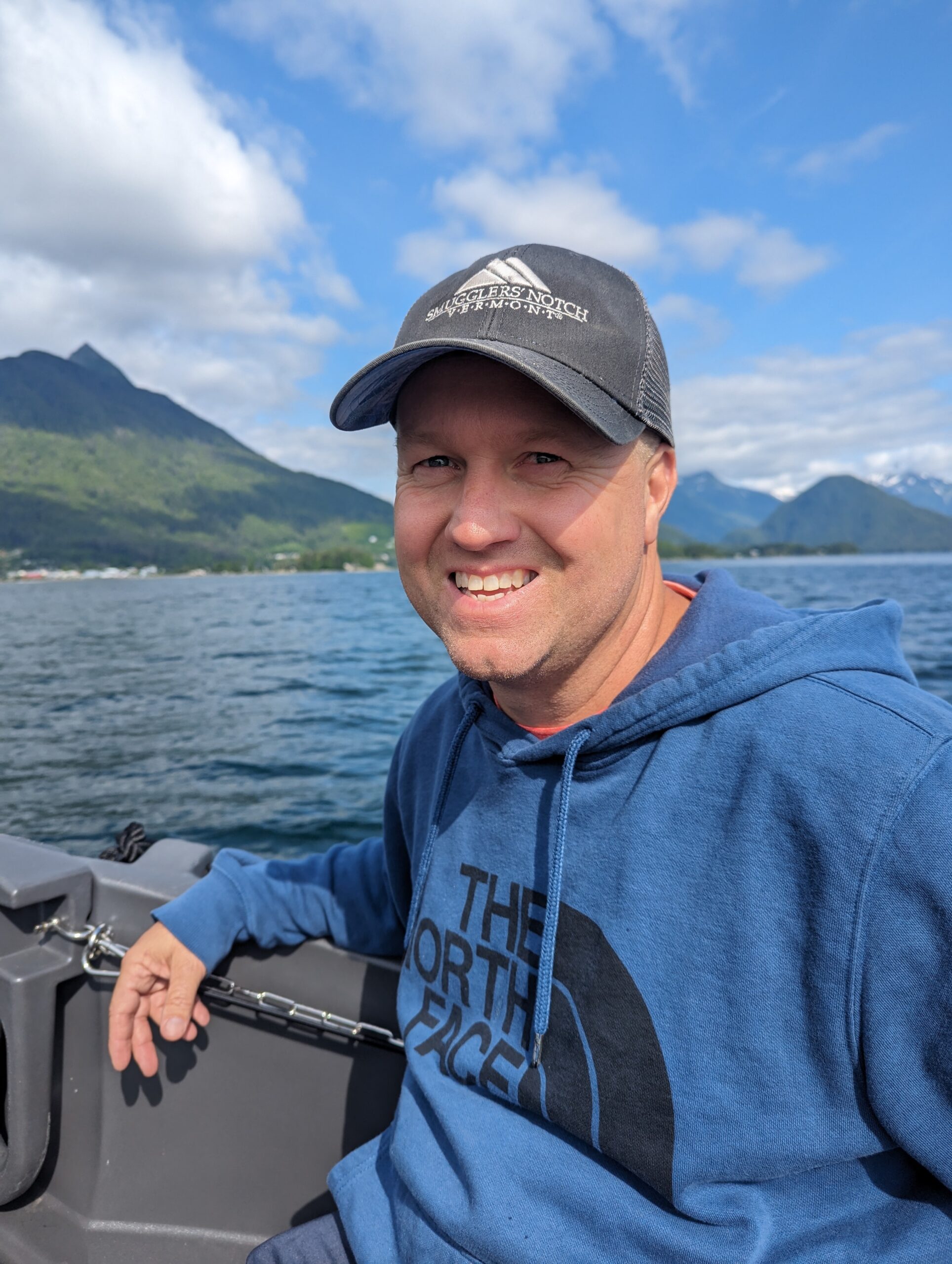 A man in blue shirt holding a fishing rod.